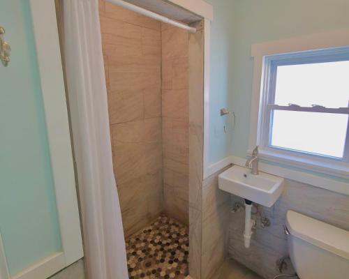 a bathroom with a shower with a toilet and a sink at Hotel on Magnolia East 'HOME' in Wildwood