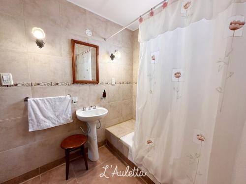 a bathroom with a sink and a shower curtain at L' Auletta in Cafayate