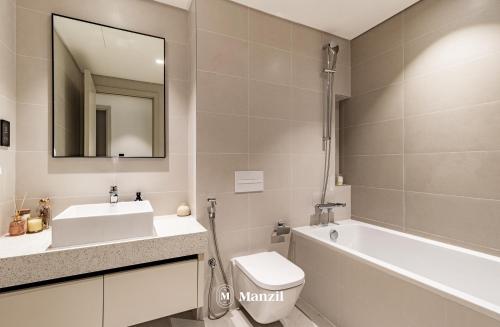 a bathroom with a sink toilet and a mirror at Manzil - 1BR Apartment in Emaar Beachfront with Private Beach & Marina Access in Dubai