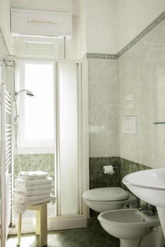 a white bathroom with a sink and a toilet at Residence Fellini in Rimini