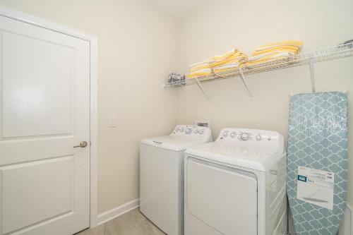 uma lavandaria com máquina de lavar e secar roupa em 2731EE VILLA 5 BED/5 BA (SANITIZED) em Kissimmee