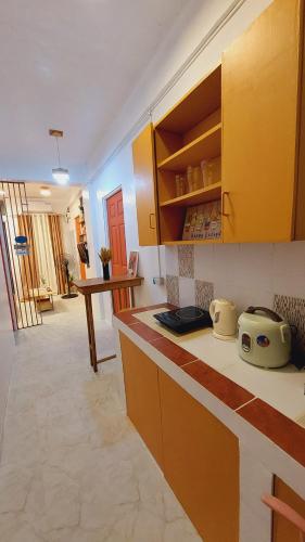 a kitchen with yellow cabinets and a counter top at Manila 1BR Cozy Homestay near UST/San Lazaro in Manila