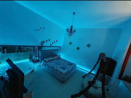 Habitación azul con cama y bañera en Dolce Appartamento al centro di Civitavecchia, en Civitavecchia