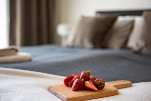 two strawberries on a cutting board on a bed at Järvevaatega apartment in Viljandi