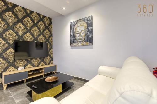 a living room with a white couch and a tv at Beautiful 3BR Triplex penthouse with Hot-Tub by 360 Estates in Il-Gżira