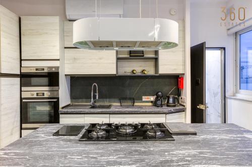 a kitchen with a sink and a stove at Beautiful 3BR Triplex penthouse with Hot-Tub by 360 Estates in Il-Gżira