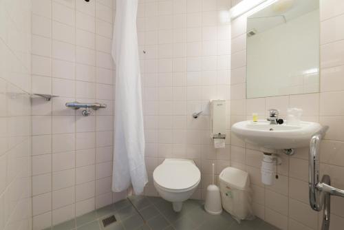 a white bathroom with a toilet and a sink at University of Exeter - Holland Hall in Exeter