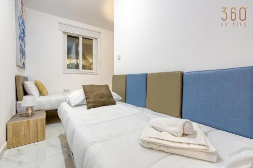 a room with two beds with towels on them at Beautiful 3BR Triplex penthouse with Hot-Tub by 360 Estates in Il-Gżira