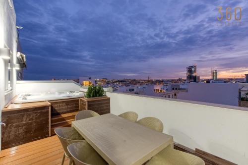 a room with a table and chairs on a balcony at Beautiful 3BR Triplex penthouse with Hot-Tub by 360 Estates in Il-Gżira