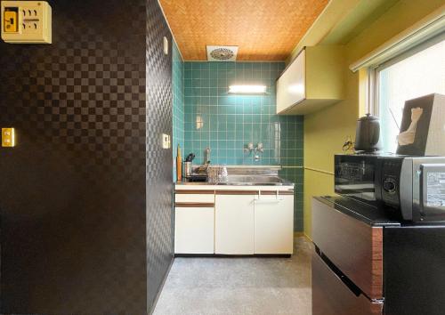 a small kitchen with a sink and a microwave at 抹茶庵世田谷東京 Matcha-An Setagaya Tokyo in Tokyo