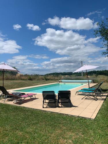 - une piscine avec des chaises et des parasols sur la terrasse dans l'établissement Hugo at Bassinaud, à Juignac