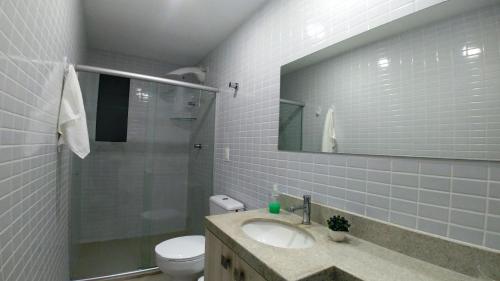y baño con lavabo, aseo y espejo. en Areias do Mar ! 3 quartos com Varanda A212, en Barra de São Miguel
