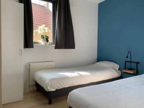 - 2 lits dans une chambre avec fenêtre dans l'établissement Groenlake Villa 16 - 6 persoons vakantie bungalow, à Ewijk