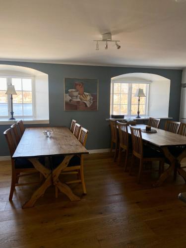 a dining room with two wooden tables and chairs at Ericsbergs Slott in Katrineholm