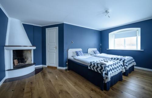 Cette chambre bleue comprend 2 lits et une cheminée. dans l'établissement Ericsbergs Slott, à Katrineholm