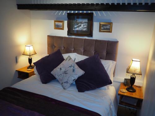 a bedroom with a bed with blue pillows and two lamps at Ashfield House in Pateley Bridge