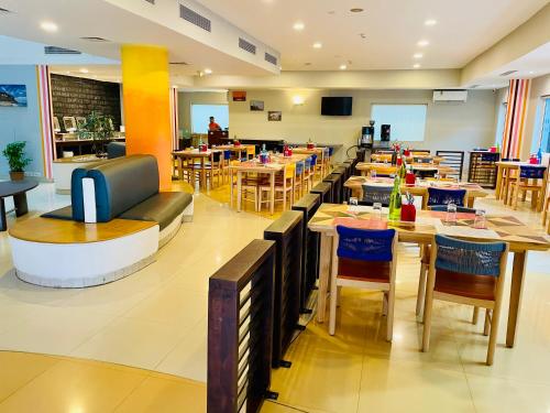 restaurację ze stołami i krzesłami oraz kawiarnię w obiekcie Ginger Trivandrum w mieście Kazhakuttam