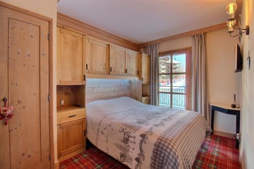 a bedroom with a bed and a large window at Appartement T3 ARC 1950 skis aux pieds Sauna, Hammam, Jacuzzi in Arc 1950