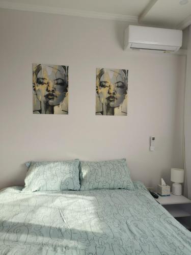 a bedroom with a bed with two pictures on the wall at Приватний будинок в Миколаєві з гаражем Private House in Mykolaiv with garage in Mykolaiv