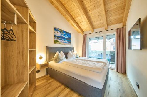 a bedroom with a bed and a large window at Apartments Lakeside 29 Zell am See in Zell am See