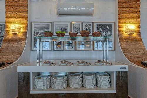 a shelf with plates on it in a restaurant at Hotel Carvoeiro Plaza in Carvoeiro