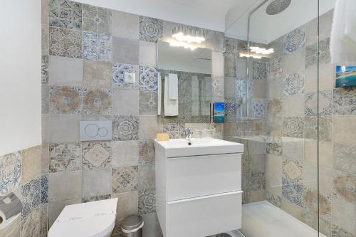 a bathroom with a toilet and a sink and a shower at Hotel Carvoeiro Plaza in Carvoeiro