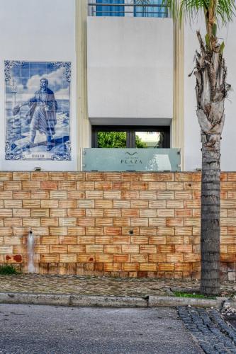 a brick wall with a window and a picture of a hockey player at Hotel Carvoeiro Plaza in Carvoeiro