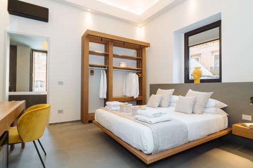 a bedroom with a large white bed and a desk at ETNEA Suite 270 in Catania