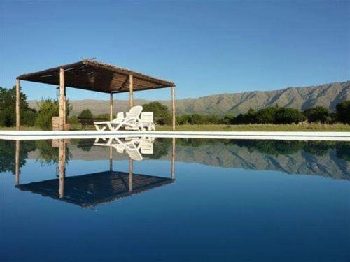 una silla blanca sentada sobre una piscina de agua en Rancho la Peregrina en Nono