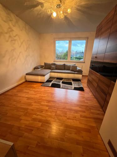 uma sala de estar com um sofá e um piso de madeira em Gemütliche Ferien-/Monteurenwohnung in Herne em Herne