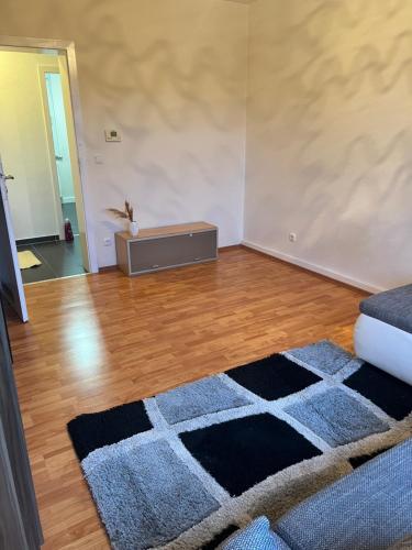 uma sala de estar com um tapete num piso de madeira em Gemütliche Ferien-/Monteurenwohnung in Herne em Herne