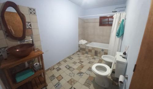 een badkamer met een toilet, een wastafel en een bad bij Rincón de Afrodita in San Lorenzo