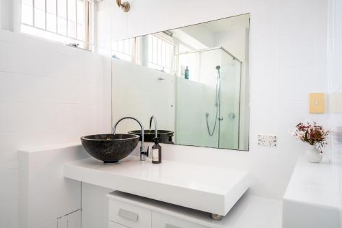 a bathroom with a sink and a mirror at Riverside 2 Bedroom apartment with parking in Brisbane
