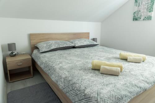 a bedroom with a large bed with two yellow pillows at Sunny day apartments in Sveta Nedjelja