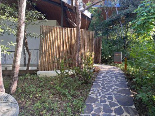 a walkway in front of a house with a fence at Suitree Experience Hotel in Guanacaste