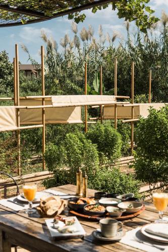 a wooden table with plates of food on it at Phāea Cretan Malia, a Member of Design Hotels in Malia
