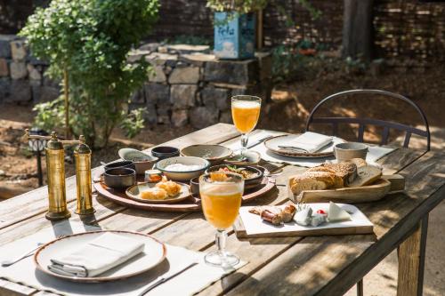 einen Holztisch mit Teller mit Speisen und Getränken darauf in der Unterkunft Cretan Malia Park a Member of Design Hotels in Malia