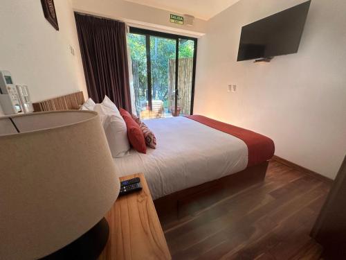 a bedroom with a bed with a large window at Suitree Experience Hotel in Guanacaste