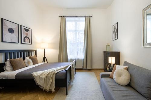 um quarto com uma cama e um sofá em WAWELOVE spacious 3 bedroom apt 1 min to Main Sq! em Cracóvia