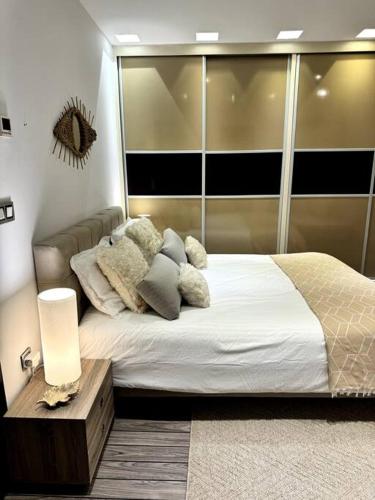 sypialnia z dużym łóżkiem z poduszkami w obiekcie Luxury villa with a heated indoor pool and direct access to the beach w mieście Nabul