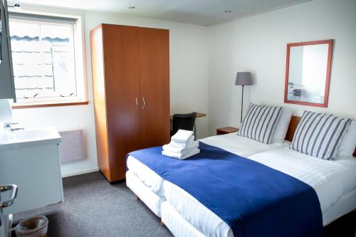 a hotel room with two beds and a window at Hotel Café Restaurant Heineke in Loosdrecht