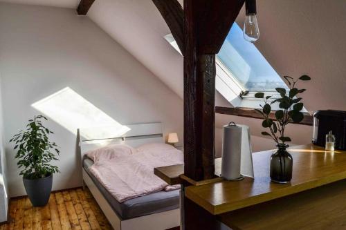 een kleine slaapkamer met een bed en een raam bij Schöne Dachgeschosswohnung nahe Köln in Keulen