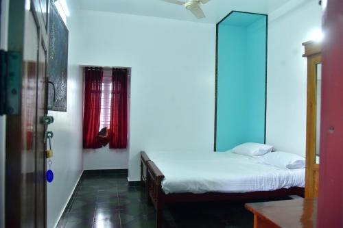 a bedroom with two beds and a mirror on the wall at Suryas Rooms in Varkala