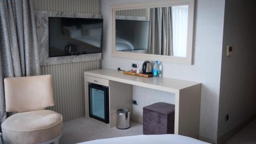 a hotel room with a fireplace and a mirror at Kervansaray Bursa City Hotel in Bursa