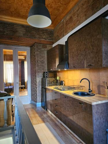 トビリシにあるOld Gold Apartmentのシンクとカウンタートップのあるキッチン