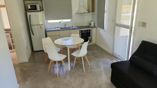 una pequeña cocina con mesa y sillas en una habitación en Cabañas El Rincon en Tandil