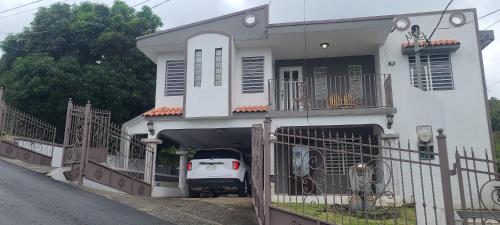 um carro está estacionado numa garagem numa casa em Country Paradise em Naguabo