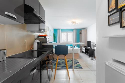 une cuisine avec un évier et une table avec des chaises dans l'établissement Pupat, à Marseille