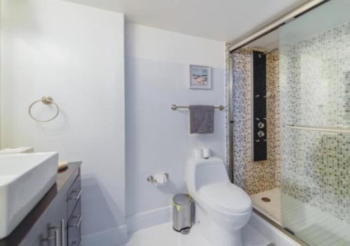 a white bathroom with a toilet and a shower at Stunning 3 Bed Condo With Ocean View in Miami