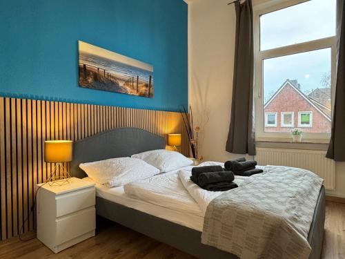 Schlafzimmer mit einem Bett mit blauer Wand in der Unterkunft Charmante Altbauwohnung an der Kesselschleuse 2 in Emden